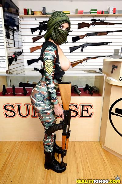 Camouflaged chick with rifle in hand lets her big natural breasts loose